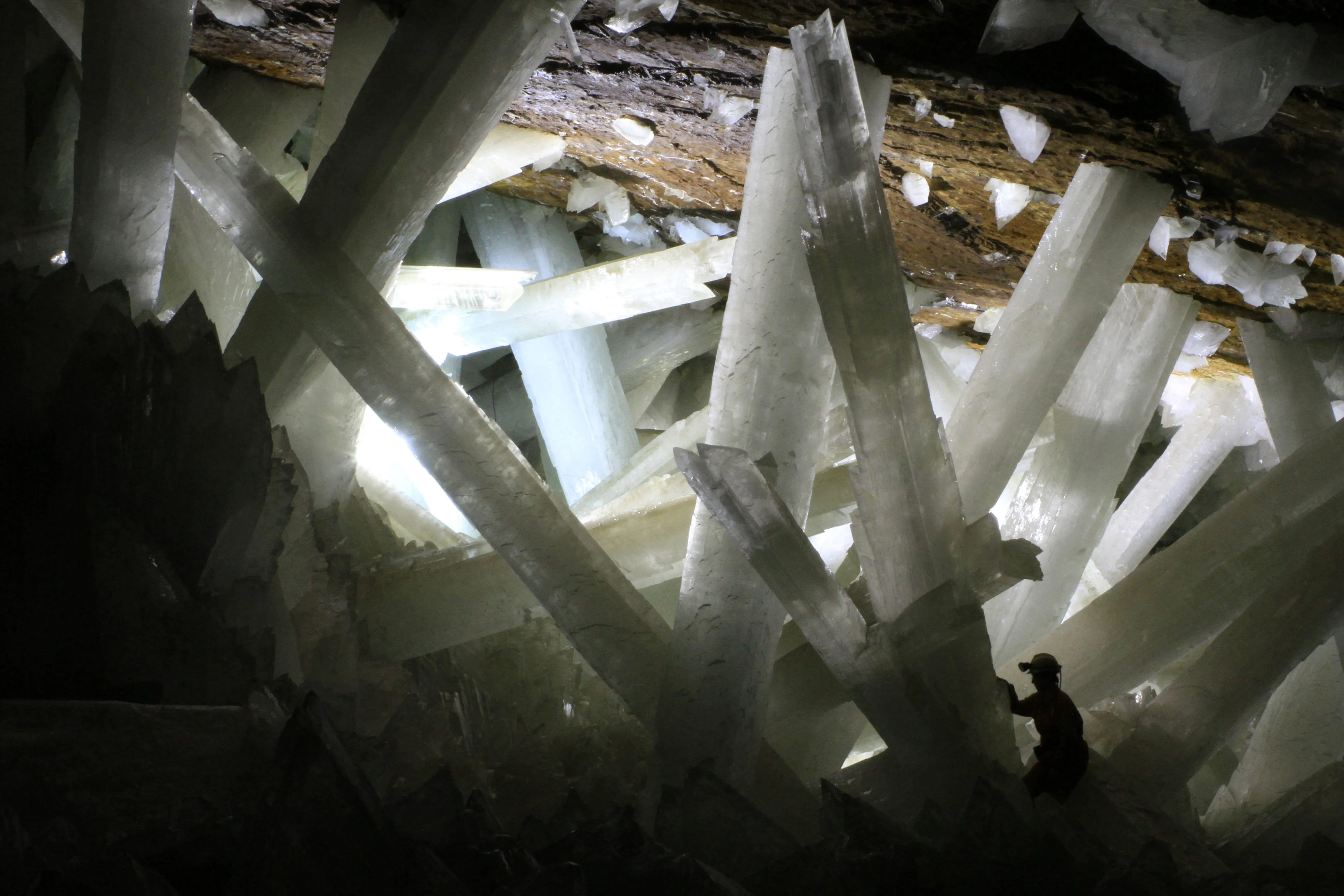 Giant translucent selenite crystals in the Naica cave, with a person at the base for scale