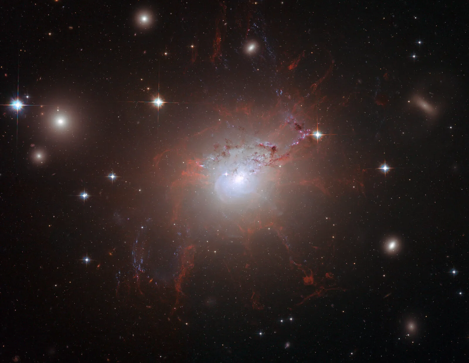 Hubble Space Telescope image of NGC 1275 showing thread-like filaments of cool gas suspended by magnetic fields, surrounded by 100-million-degree gas