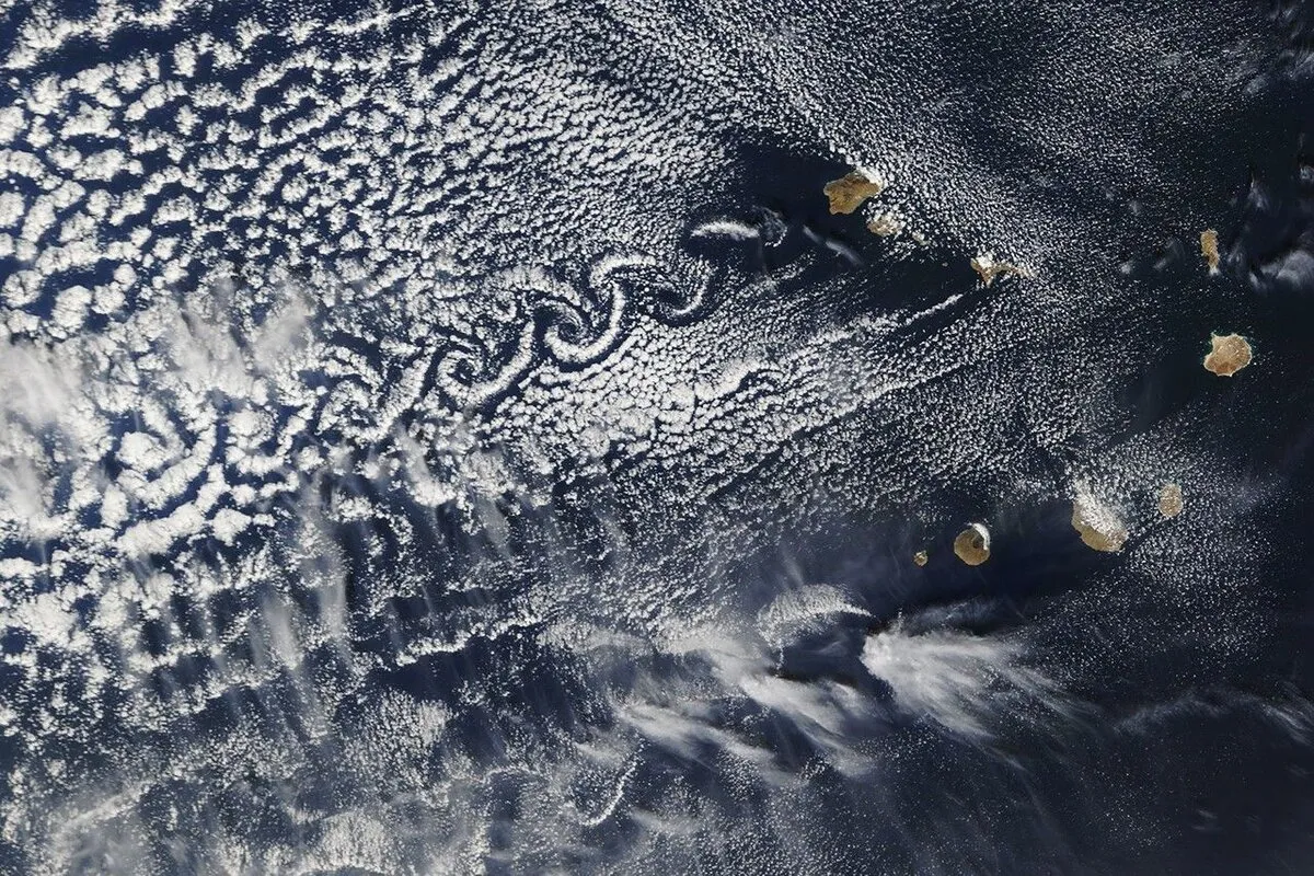 Von Kármán vortex streets forming in clouds downstream of the Cabo Verde islands, seen from space